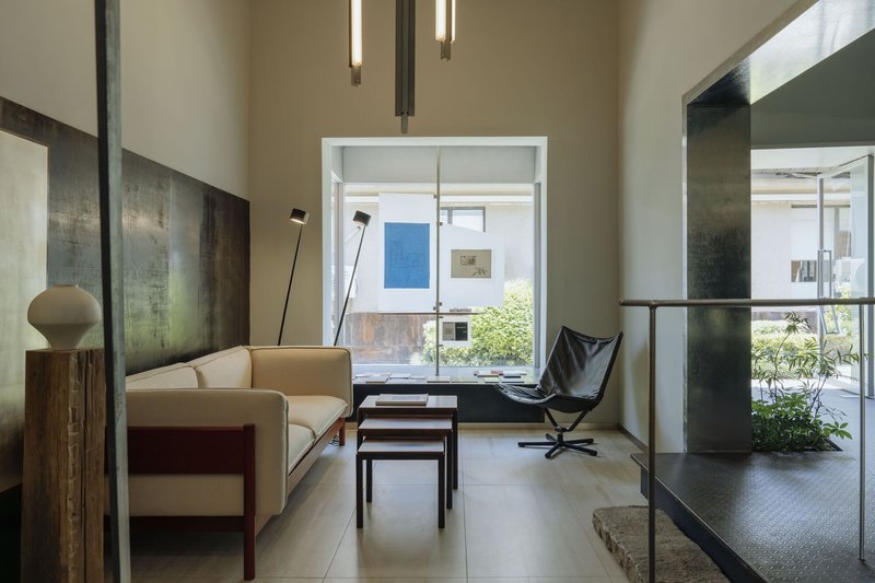 Living area with seating looking through to a courtyard garden with steel-clad partition