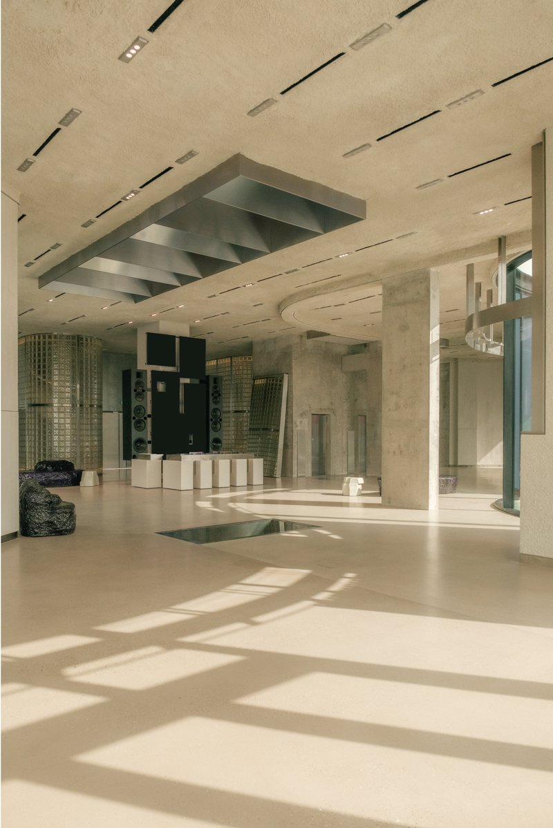 Ground floor with layered glass ceiling louvers casting shadows across polished concrete floor