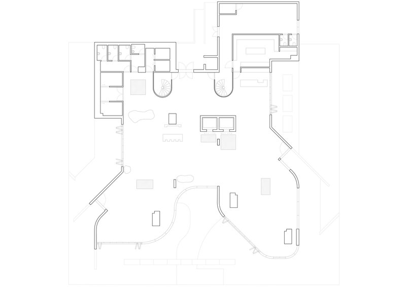 Floor plan drawing showing an open layout with curved perimeter walls and clustered service zones
