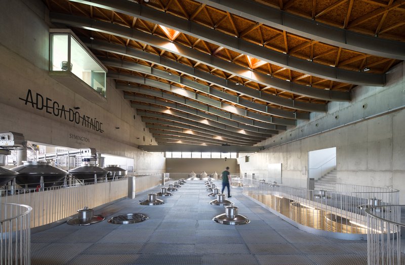 Interior processing floor with fermentation tanks, concrete walls and illuminated timber truss ceiling