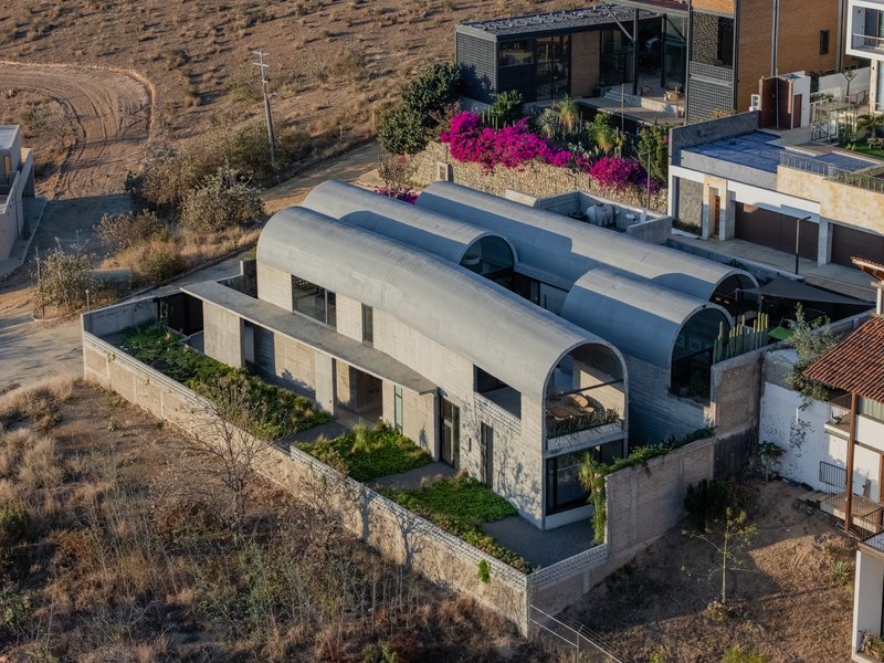 Aerial view of the residence with three parallel barrel vaults on a terraced hillside site