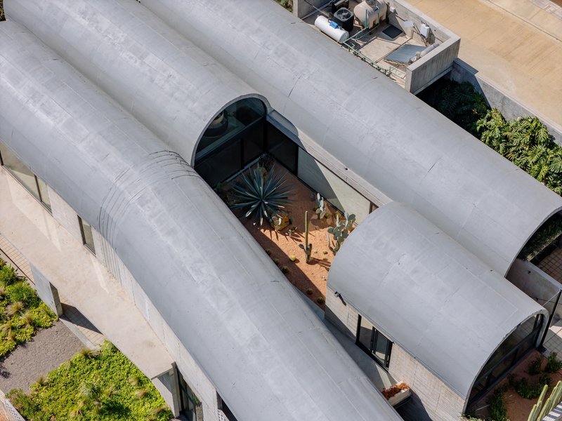 Aerial view of the barrel-vaulted concrete roof with central courtyard planted with agave and cacti