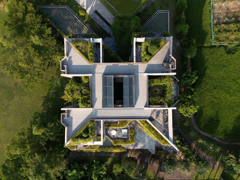 Drone view showing the planted roof terraces and white concrete volumes arranged around courtyards