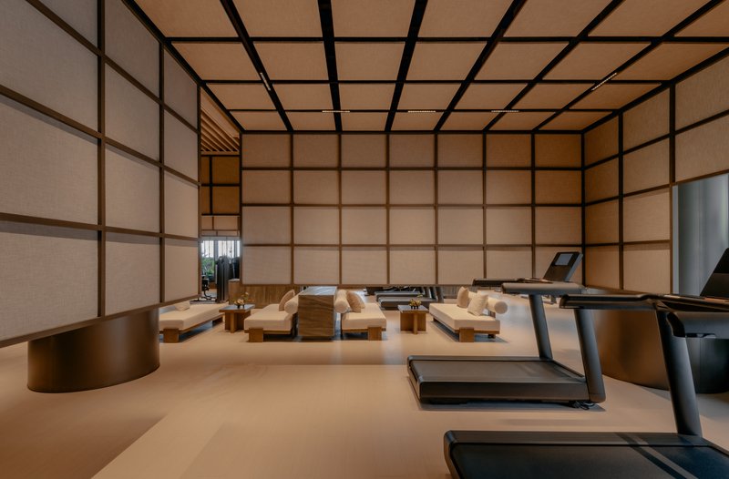 Exercise room with low platform seating surrounded by translucent panel walls with dark framing