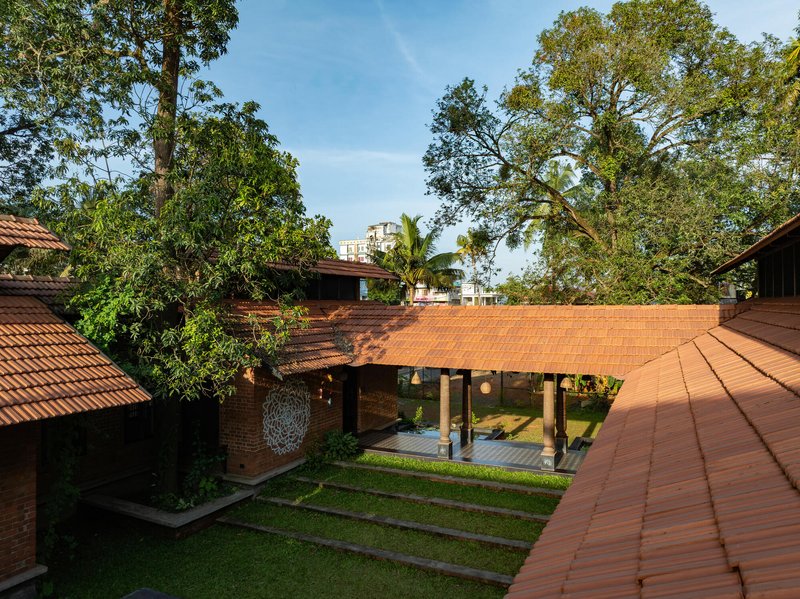 Courtyard view of a covered pavilion with timber columns under a terracotta tile roof