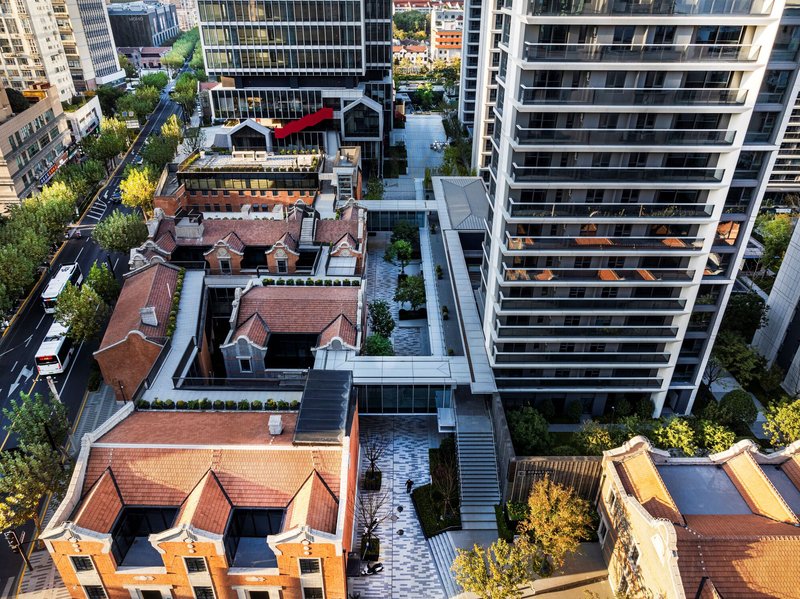 Aerial view of preserved terracotta-roofed houses connected by landscaped terraces and stairs between tower blocks
