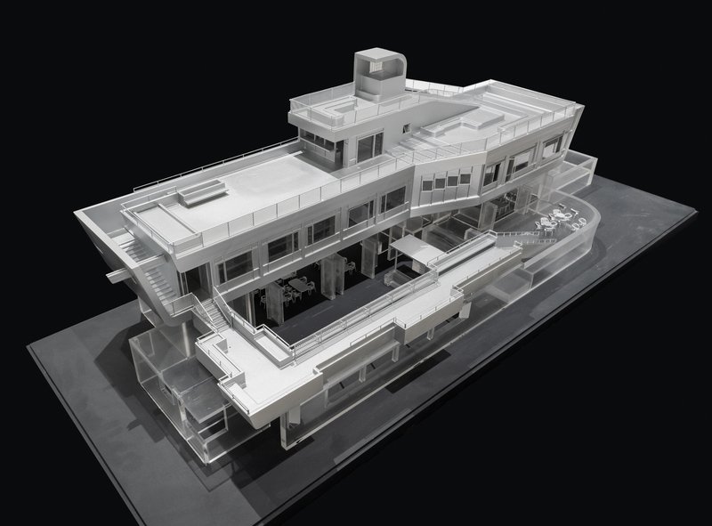 Physical model in angled view revealing layered horizontal terraces and a cylindrical rooftop element