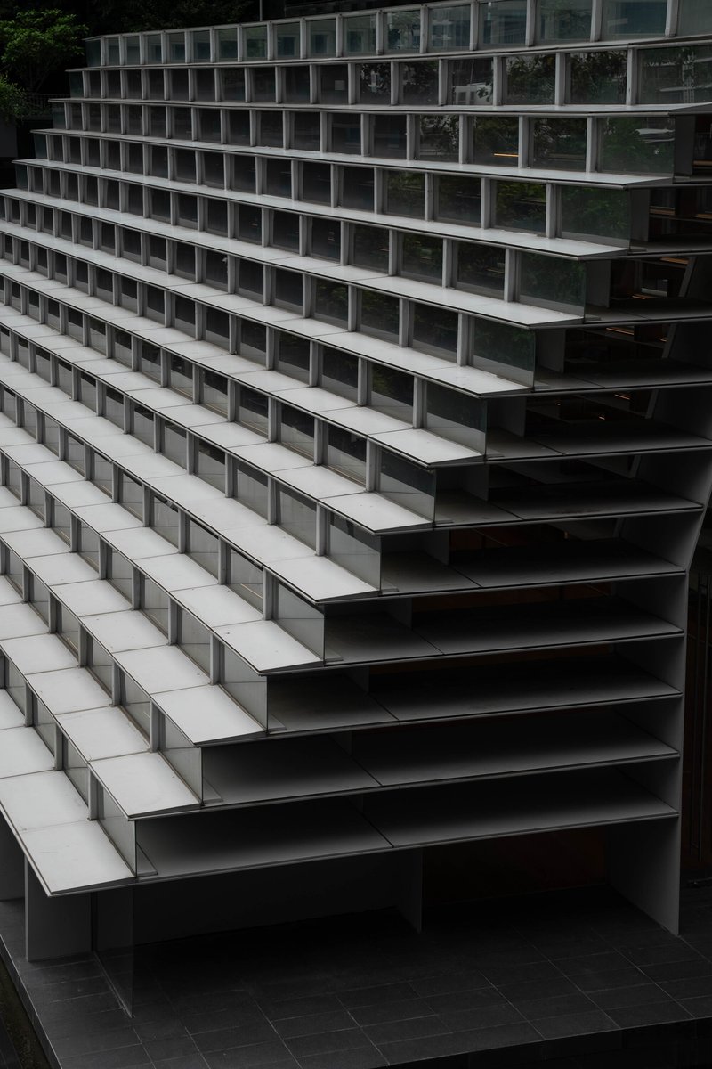 Close-up of terraced seating steps with alternating dark metal risers and pale horizontal treads