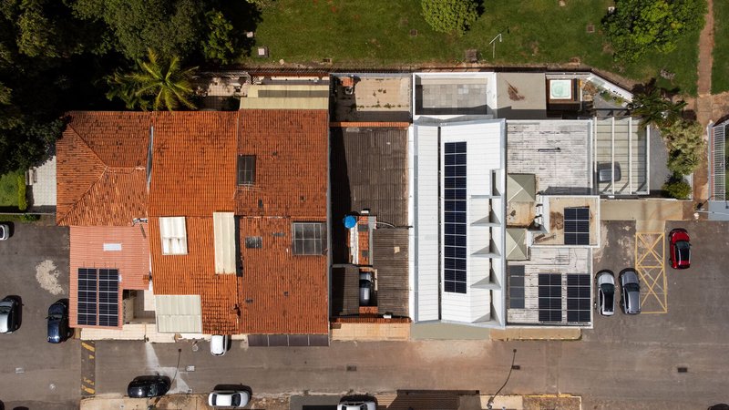Overhead view of connected houses showing terracotta tile roofs and a new white flat roof volume