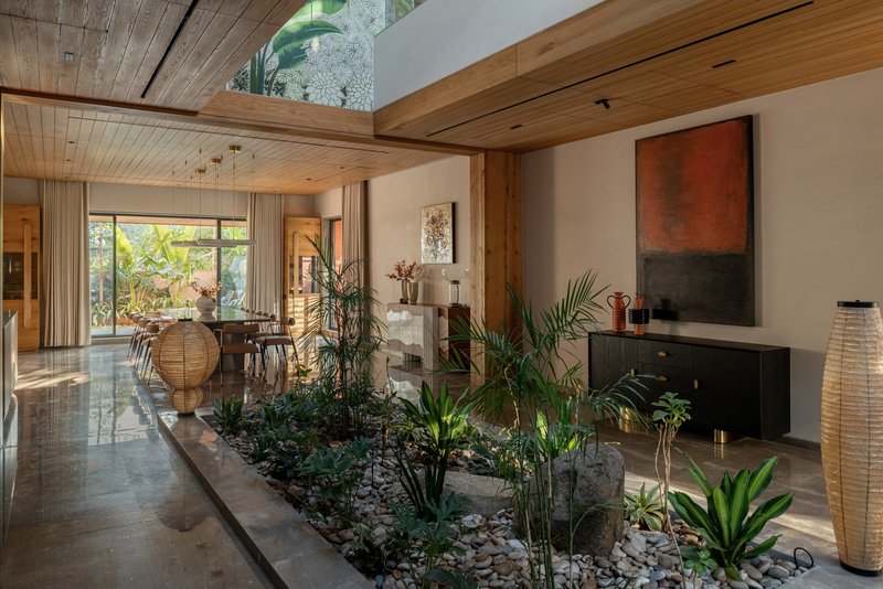 Interior planted courtyard with tropical foliage under timber and glass skylight ceiling
