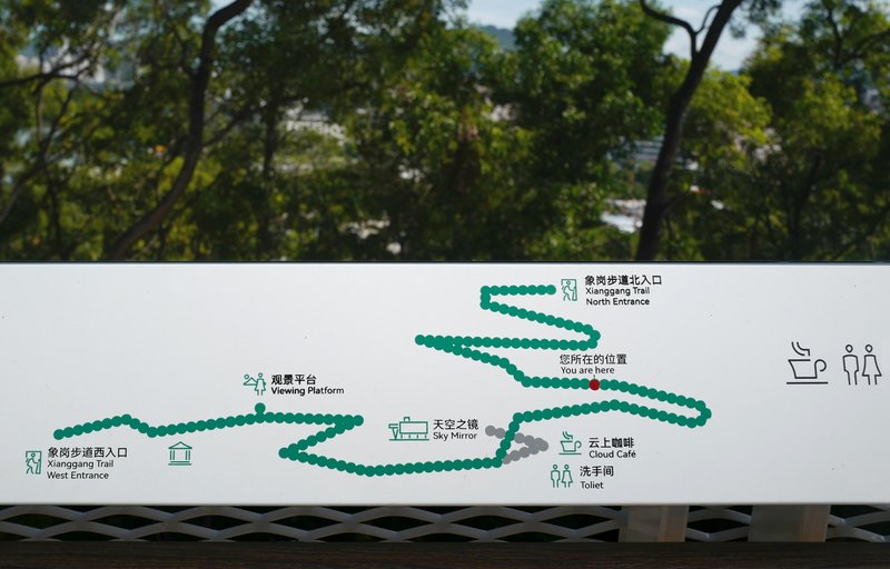 Wayfinding map panel showing the looping trail route with green dot markers and facility icons