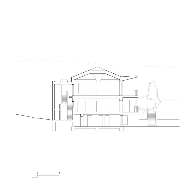 Section drawing showing a three-story residence with gabled roof and stairs on sloped terrain