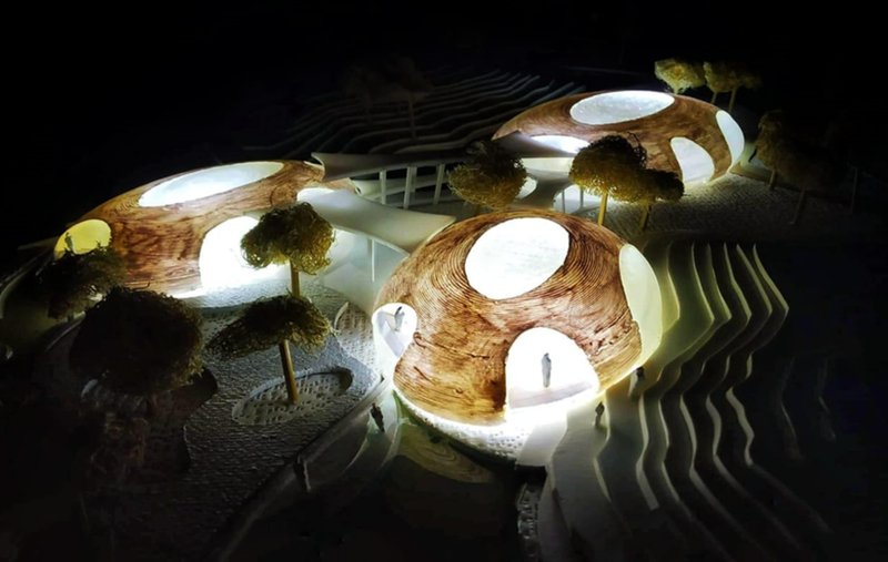Illuminated architectural model showing the river-inspired aquarium form merging with landscape and water.
