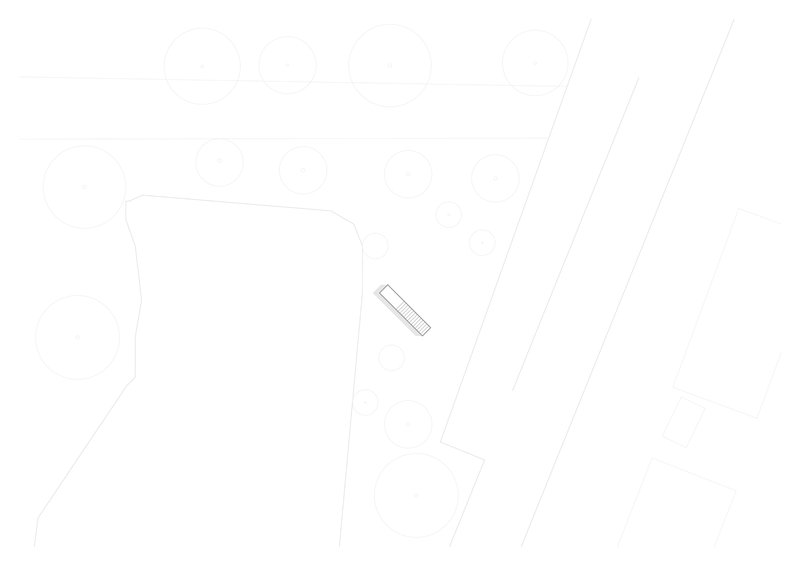 Site plan drawing depicting the elongated building form on sloping terrain between organic boundaries