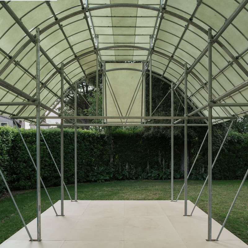 Interior view through the steel ribbed vault looking out to the garden and hedge beyond