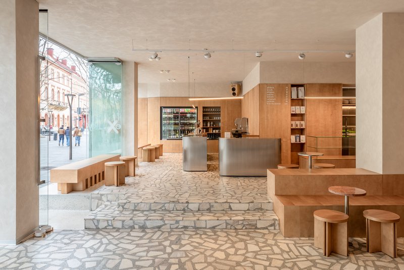 Ground floor retail space with terrazzo flooring and street-facing windows revealing pedestrians outside