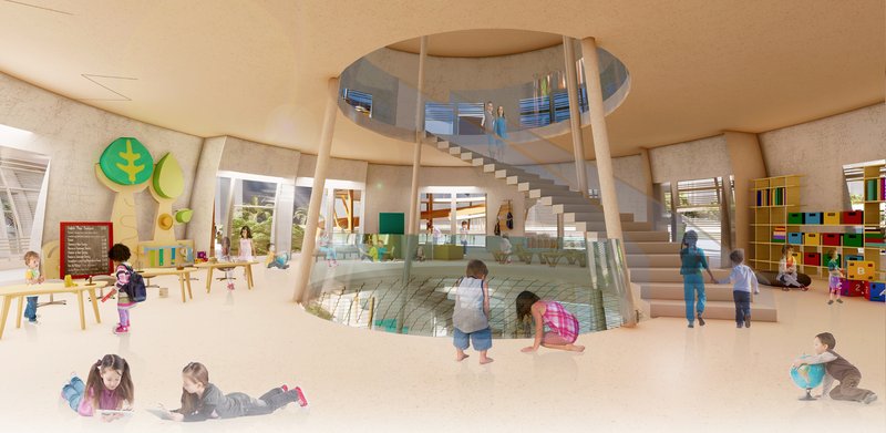 Interior view of a circular atrium with a helical staircase, glass guardrails, and children playing below on a carpeted floor