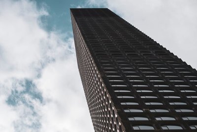 This architectural photograph showcases a tall skyscraper with a repetitive pattern of windows and c