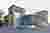 This architectural image showcases a modern industrial building with a corrugated metal facade. The 