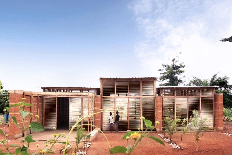 A climate-responsive school prototype, defined by rammed earth walls and timber louvers.