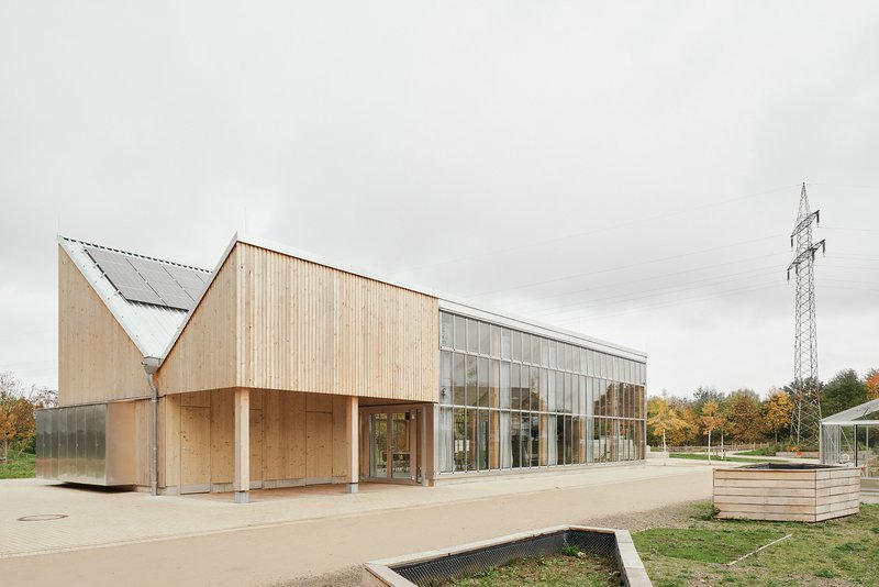 Three-quarter view of the pavilion with raised planting beds in the foreground