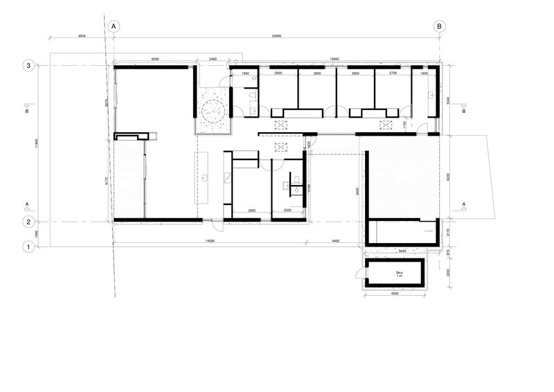 Floor plan drawing showing an L-shaped layout with multiple rooms and a circular courtyard element