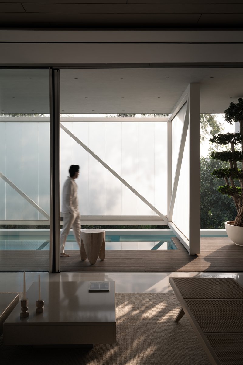 Interior living space with large glass doors opening to a deck and pool with diagonal bracing visible