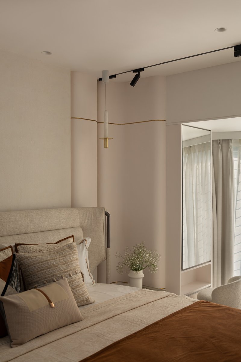 A bedroom with a slim brass-and-stone band running horizontally across the wall.