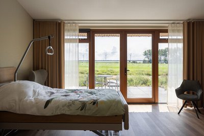 This image showcases a bright and airy hospital room designed for patient comfort and healing. The r