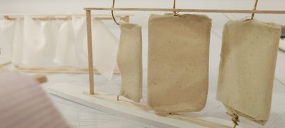 This image showcases an architectural model exploring the use of fabric within a wooden frame. The m