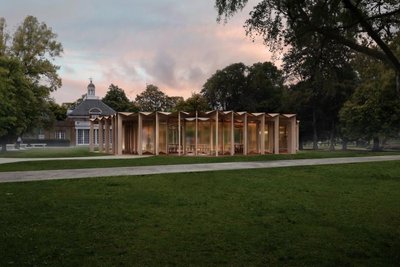 This architectural image showcases a modern pavilion situated in a park setting. The pavilion featur