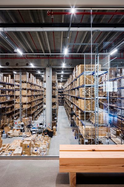 This architectural image showcases the interior of a large warehouse, characterized by its high ceil