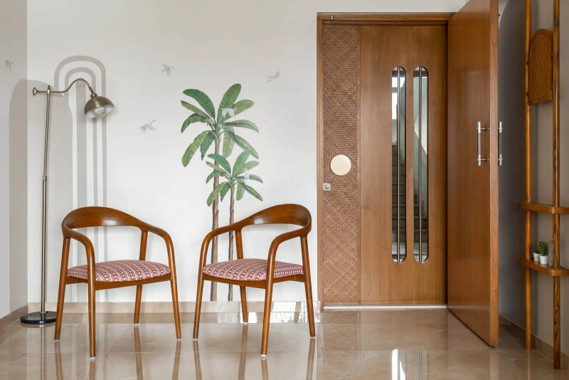 The wall adjacent to the dining flaunts a decal of coconut trees by Kalakaari Haath that adds to the vivacity of the scenario. The subtle grey arched pattern integrates this corner with the rest of the home. Anuja Kambli