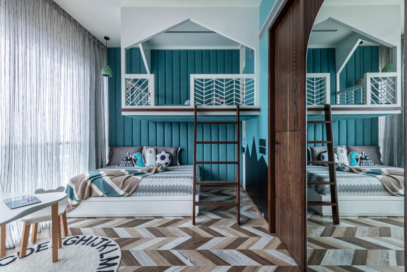 The shining star of the kids’ bedroom is the playhouse above the bed. The big teal headboard is balanced by abstract wallpaper and chevron flooring. PRASHANT BHAT