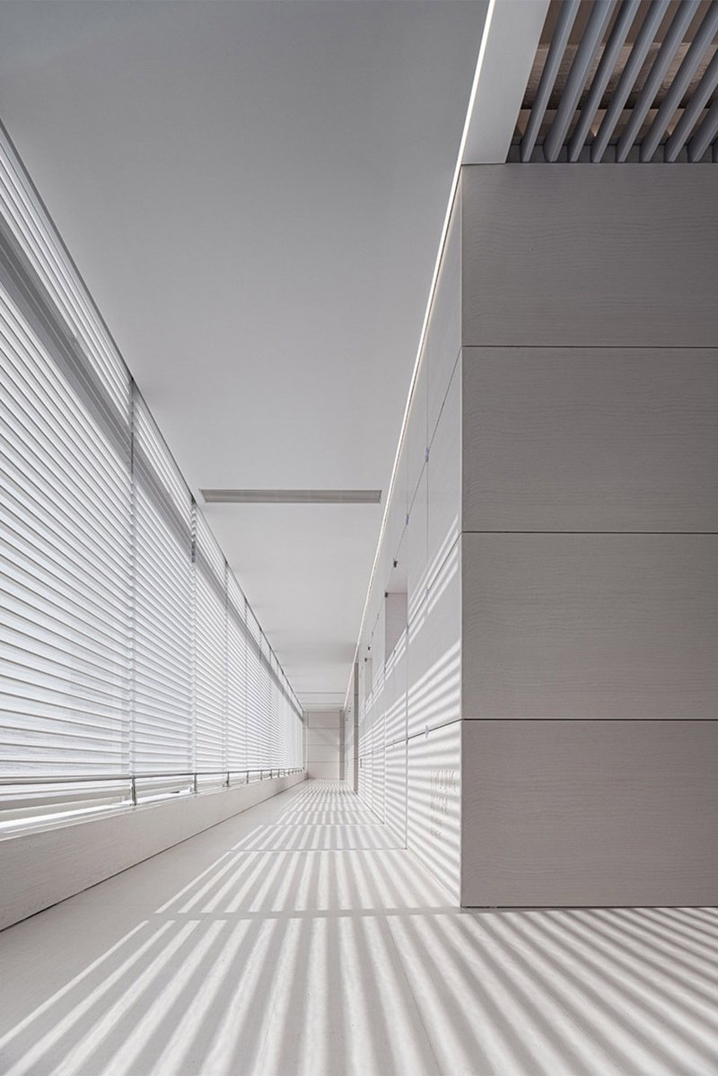 Technological lighting and linear natural light and shadow in the corridor © WYAP