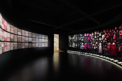 This image showcases the interior of a modern museum exhibition. The space features a curved wall di