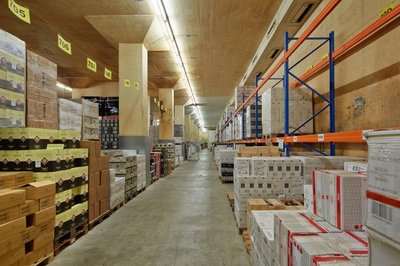 This image showcases the interior of a large warehouse, characterized by its high ceilings and rows 