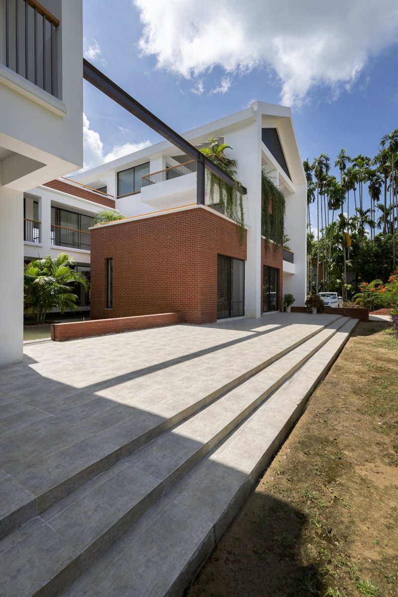 Wide concrete steps leading to the entrance plaza framed by white columns and dark beams