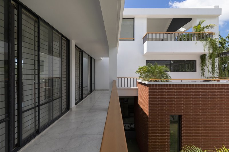 Circulation balcony with louvered screens overlooking central courtyard and brick planter volume