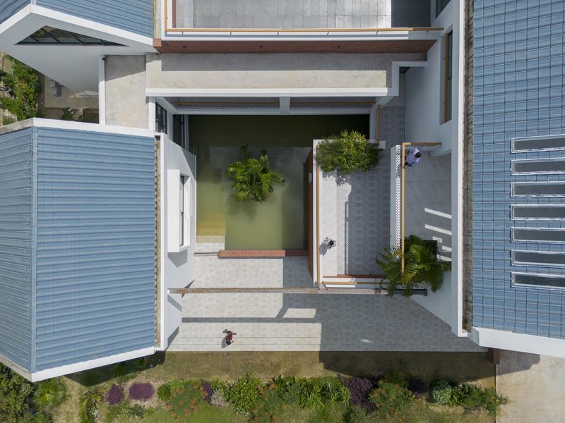 Aerial view of courtyard pool with louvered screens and timber pergola in midday sun