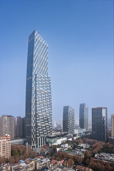 This architectural image showcases a modern skyscraper with a striking glass facade and geometric pa