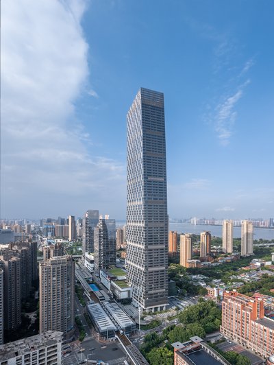This architectural image showcases a modern skyscraper dominating an urban landscape under a partly 