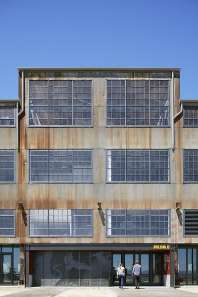 This architectural image showcases the facade of an industrial building, characterized by its corrug