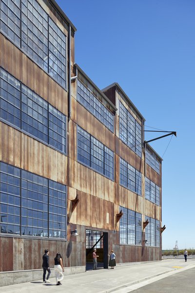 This architectural photograph showcases an industrial building with a striking facade of corrugated 