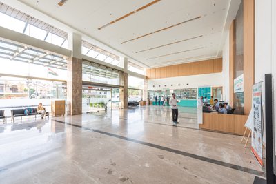 This architectural image showcases the interior of a modern hospital lobby. The space features a hig