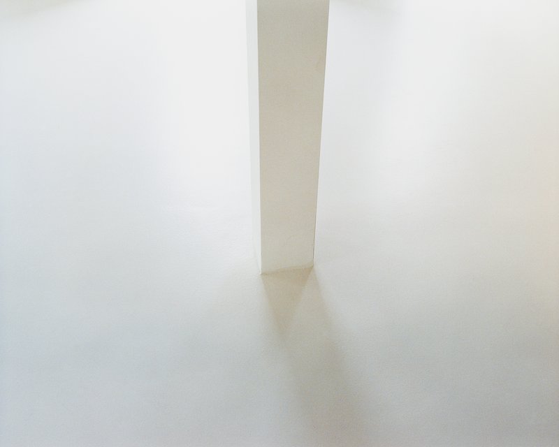Detail of the slim white pillar standing on the polished concrete floor