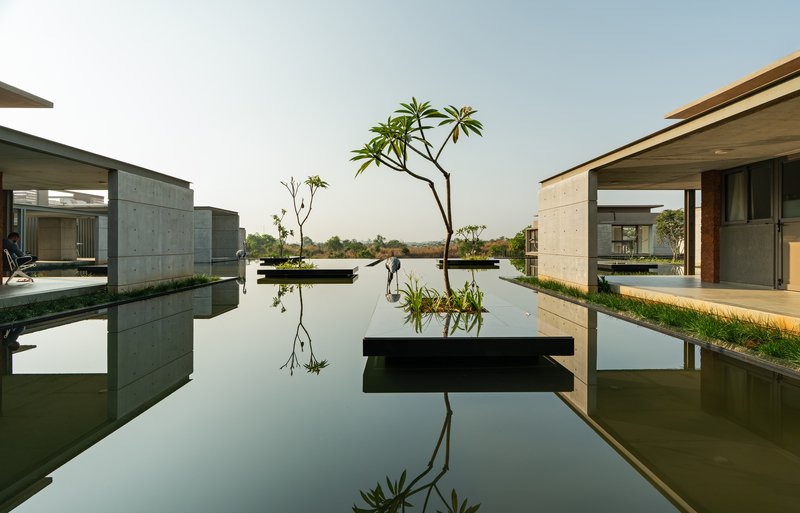 Wide view across the reflecting pool between the ward wings with a floating planter in the foreground