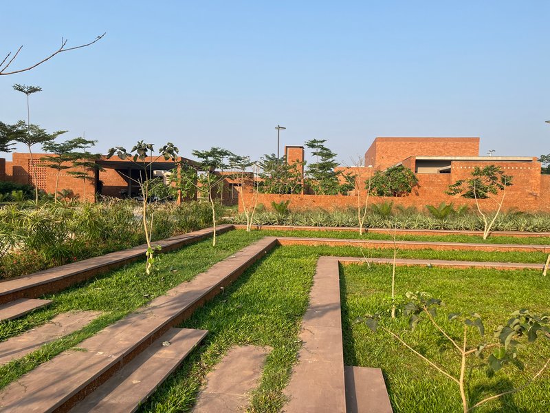 Landscaped rear garden with planted terraces and the brick complex on the horizon