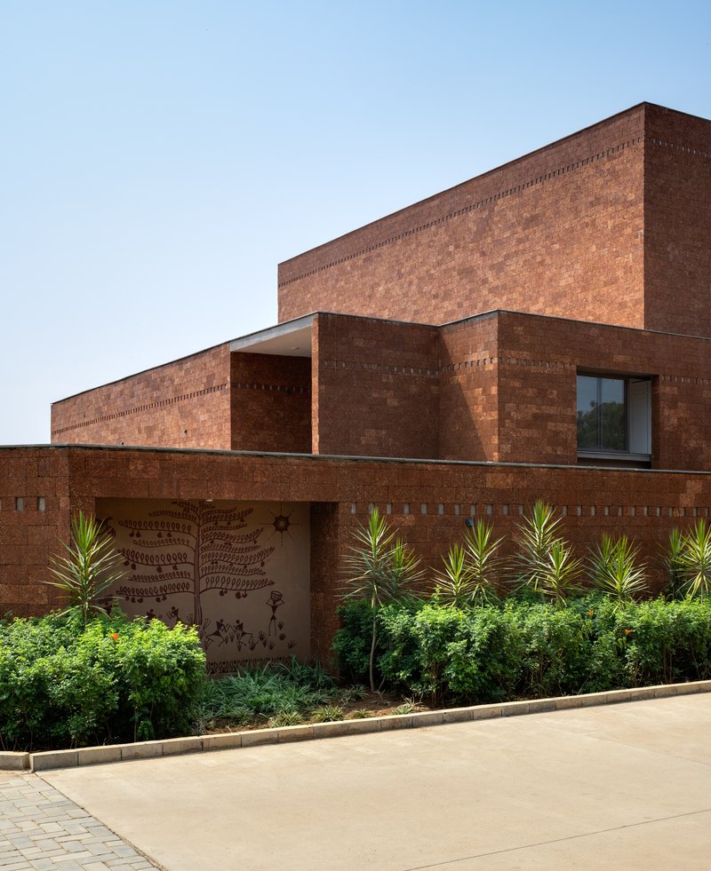 Laterite facade of the ward block with an indigenous mural carved into the lower brick wall