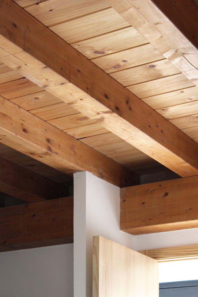 Close-up of the original heavy timber roof beams and tongue-and-groove pine ceiling